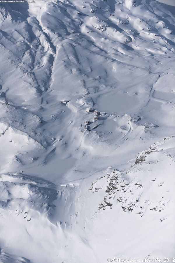 Das tief verschneite Ospizio San Gottardo, Blickrichtung NW von der Tremola zum Piz Fibbia. Gut sichtbar der grosse Lago delle Piazza.
